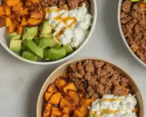 Delicious cottage cheese taco bowl filled with seasoned ground beef, fresh avocado, and drizzled with spicy sauce.