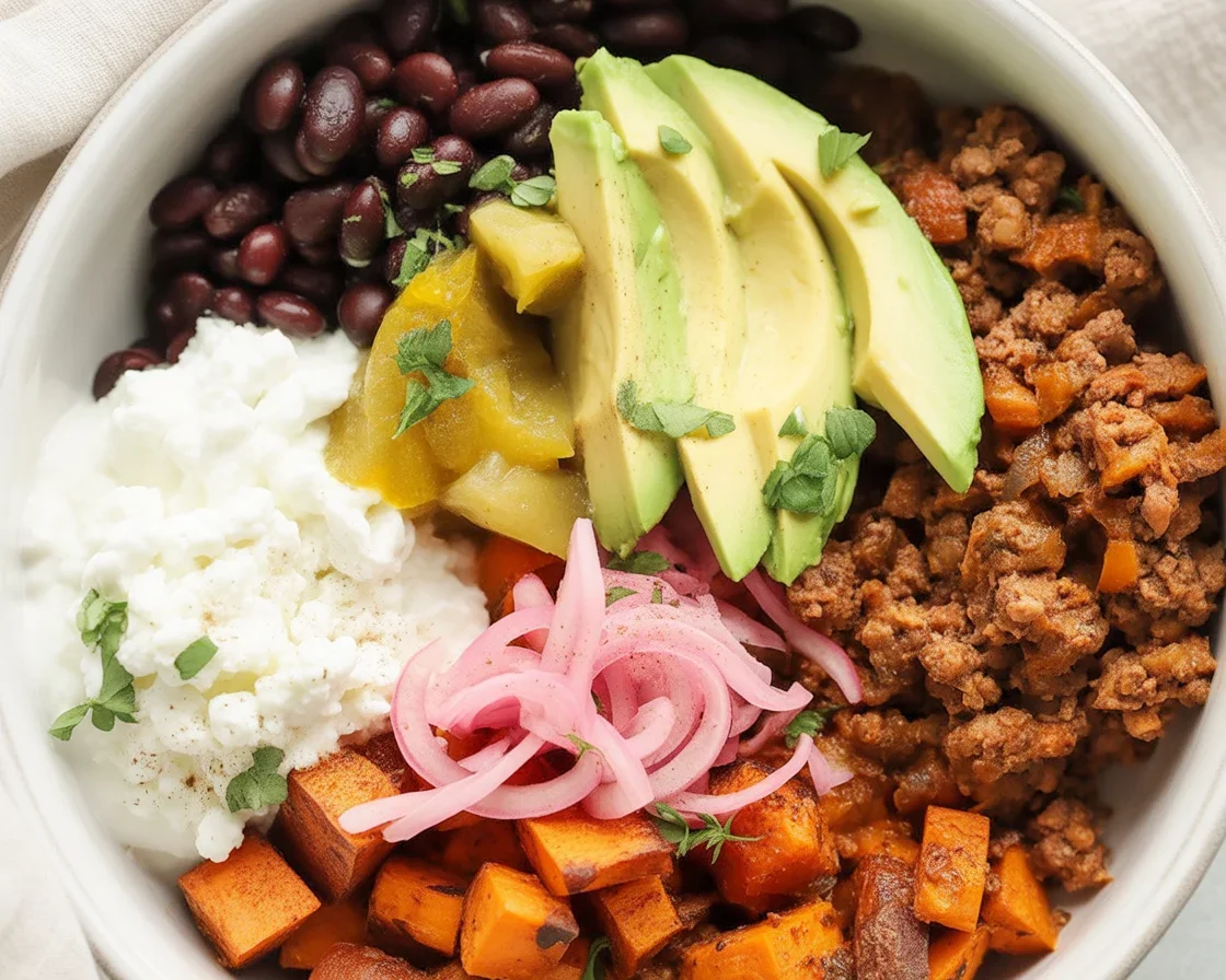 Colorful sweet potato taco bowls with toppings like avocado and beans.