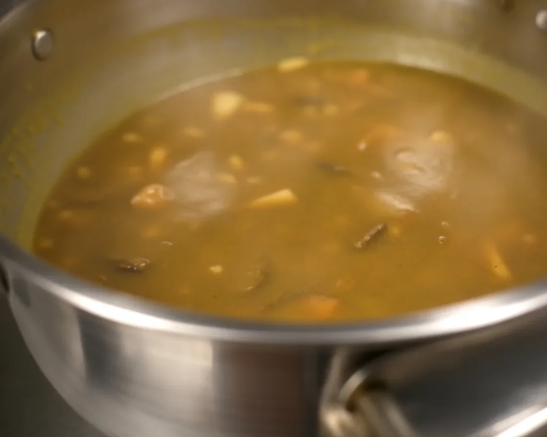 A colorful bowl of spiced flattened rice poha with vegetables and peanuts.