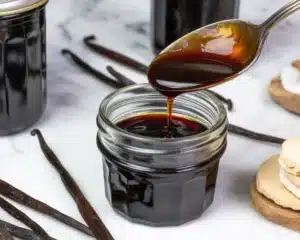 vanilla paste recipe 10 Homemade vanilla bean paste in a glass jar surrounded by vanilla beans.