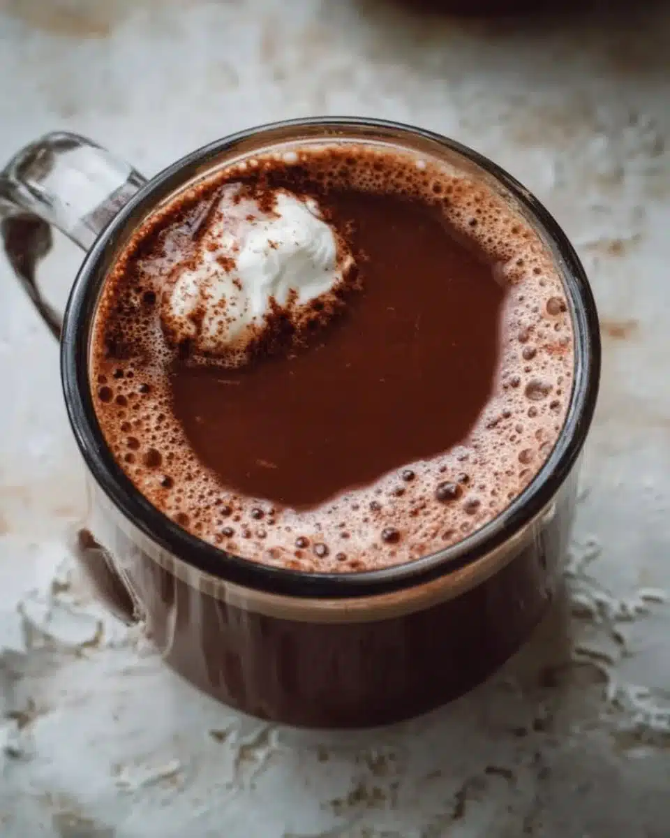 Healthy Hot Chocolate 1 Healthy hot chocolate topped with whipped cream and cocoa powder in a cozy mug