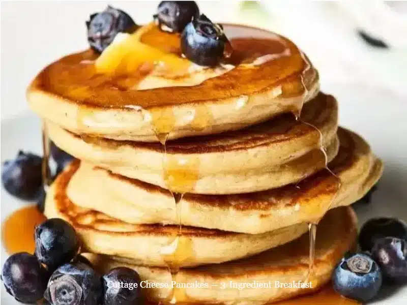 Cottage Cheese Pancakes — 3-Ingredient Breakfast 1 Plate of fluffy cottage cheese pancakes topped with syrup and berries