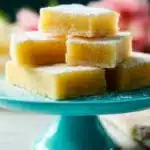 Delicious homemade lemon bars on a plate with powdered sugar topping.