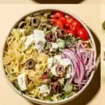 Delicious crowd-pleasing pasta salad served in a bowl with fresh vegetables.