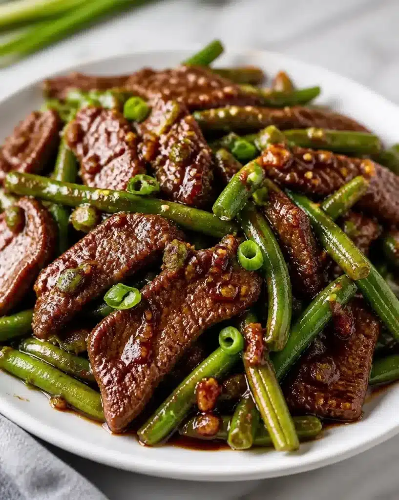 Garlic-infused griddle beef served with green beans on a plate.