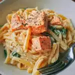 Silky salmon pasta in creamy sauce garnished with herbs