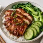 Char siu chicken rice bowl with cucumber bok choy scallions and glossy sauce